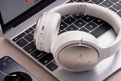 Jasne słuchawki FiiO JadeAudio JN3 leżące na laptopie
